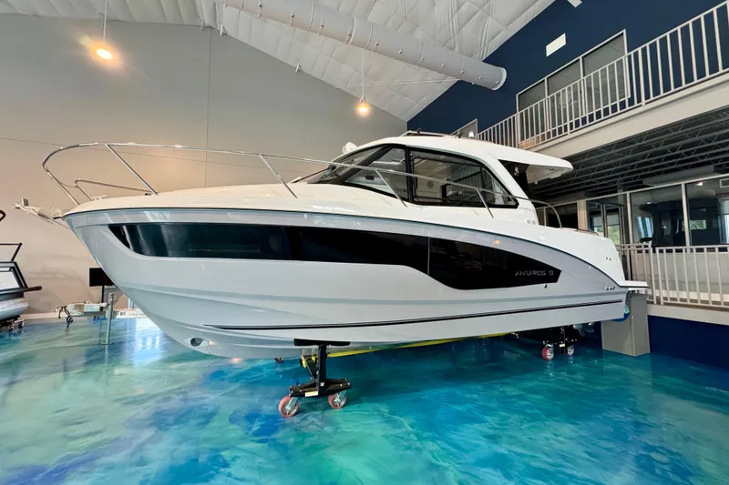 Slide: The Image of 2026 Beneteau Antares 9 boat displayed indoors on a blue floor. - 0