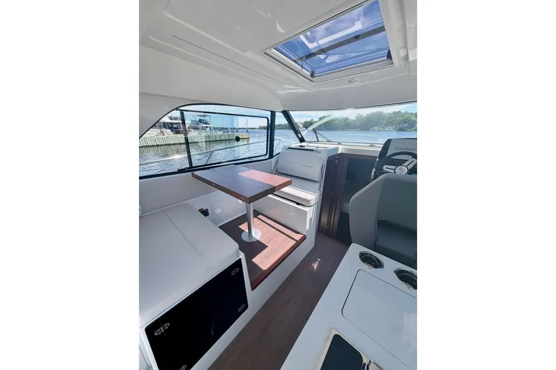 Slide: The Image of Interior of 2026 Beneteau Antares 9 boat with seating and table, overlooking water. - 29