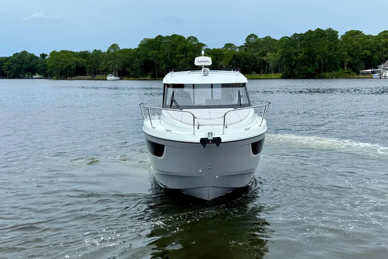 Slide: The Image of 2026 Beneteau Antares 9 boat cruising on a calm lake with forested shoreline. - 5