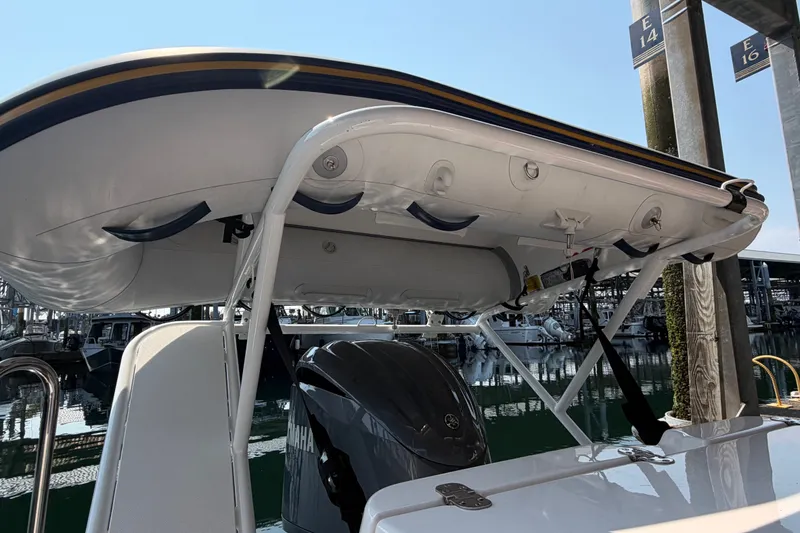 Slide: The Image of 2024 Ranger Tugs R-27 with mounted dinghy and Yamaha outboard motor at marina. - 57