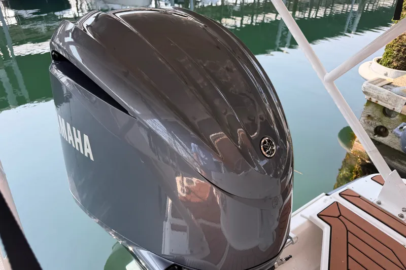 Slide: The Image of 2024 Ranger Tugs R-27 with Yamaha outboard motor, docked on calm water. - 16