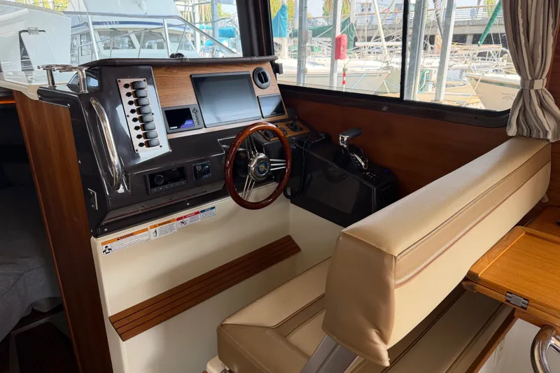 Slide: The Image of 2024 Ranger Tugs R-27 helm with modern controls and leather seating. - 23