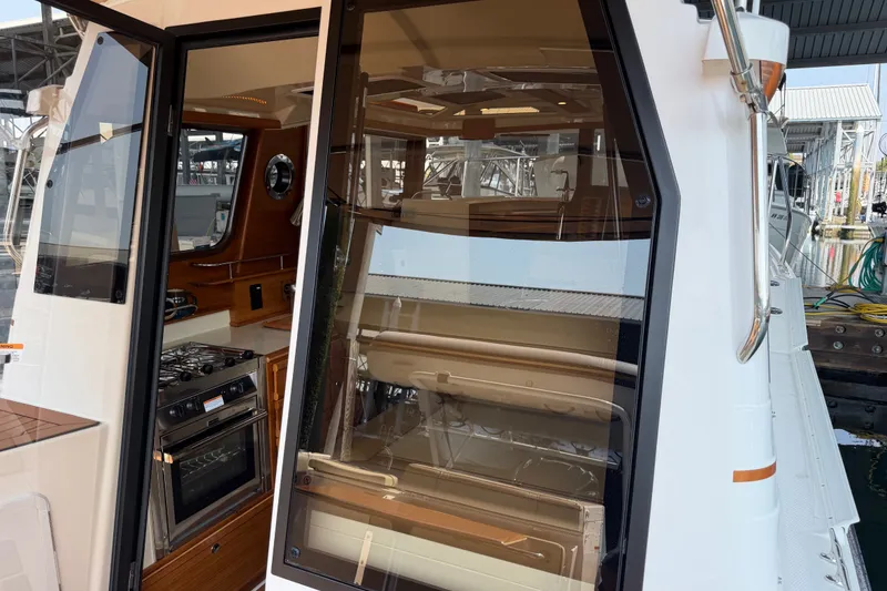 Slide: The Image of 2024 Ranger Tugs R-27 interior view with kitchen and seating area. - 18