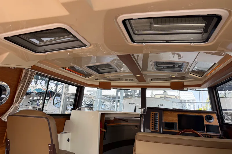 Slide: The Image of Interior of 2024 Ranger Tugs R-27 boat, featuring modern helm and panoramic windows. - 54