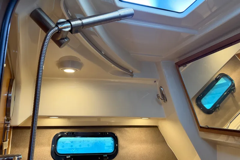 Slide: The Image of 2024 Ranger Tugs R-27 interior shower with skylight and porthole window. - 47