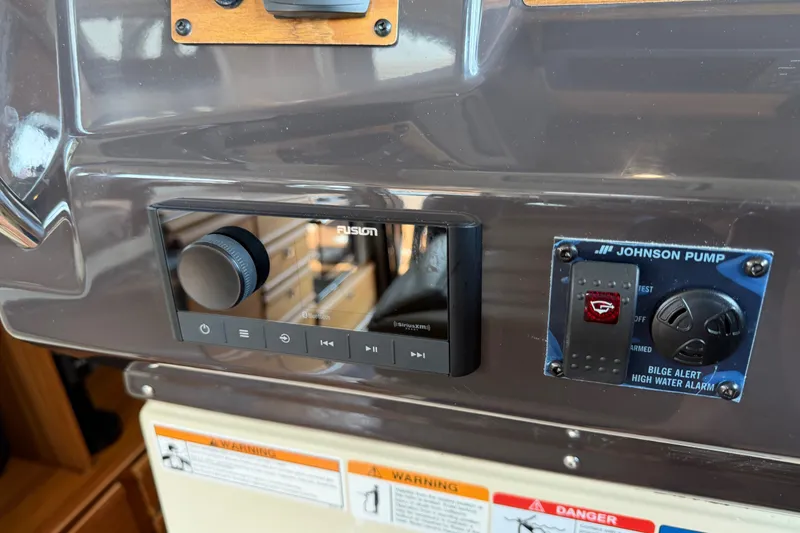 Slide: The Image of 2024 Ranger Tugs R-27 dashboard with Fusion audio system and Johnson Pump controls. - 33