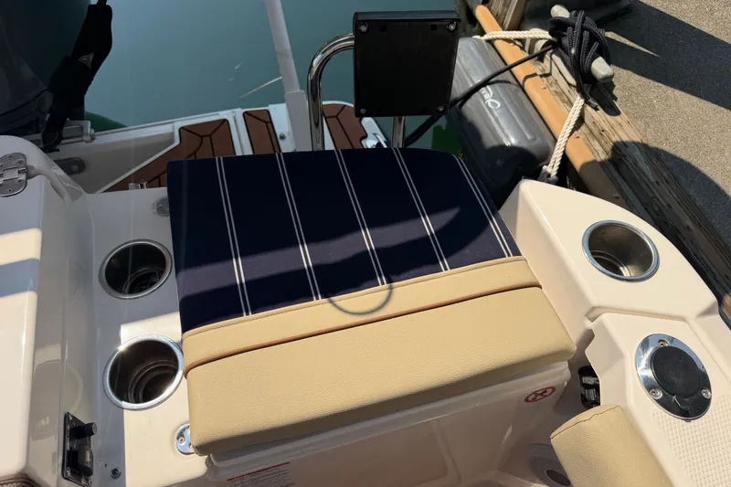 Slide: The Image of 2024 Ranger Tugs R-27 boat seating area with cup holders and striped cushion. - 11