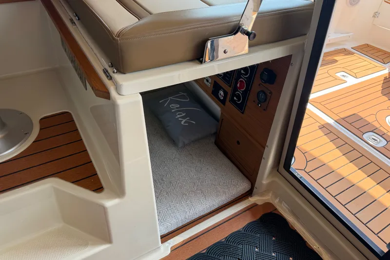 Slide: The Image of 2024 Ranger Tugs R-27 interior with cushioned seating and control panel. - 48
