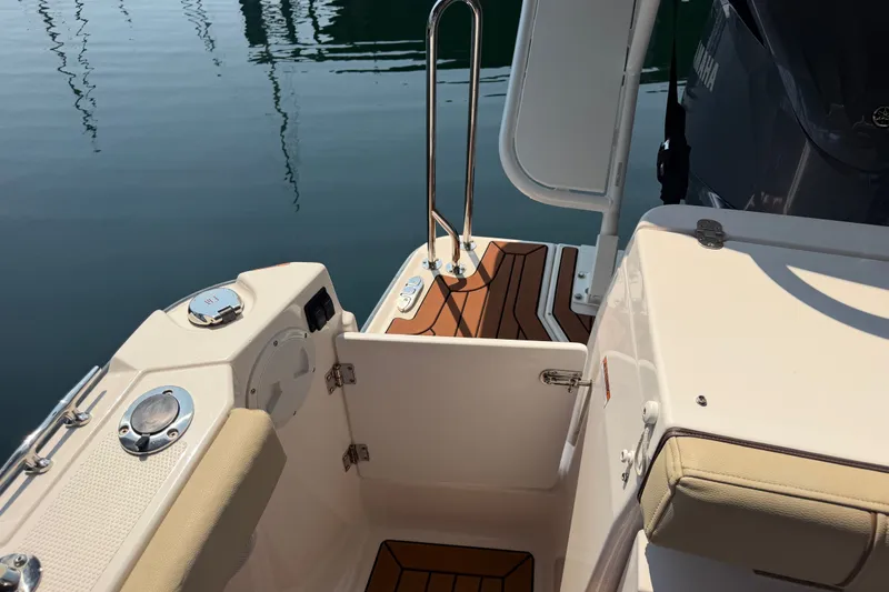 Slide: The Image of 2024 Ranger Tugs R-27 boat deck with teak flooring and stainless steel railing. - 13