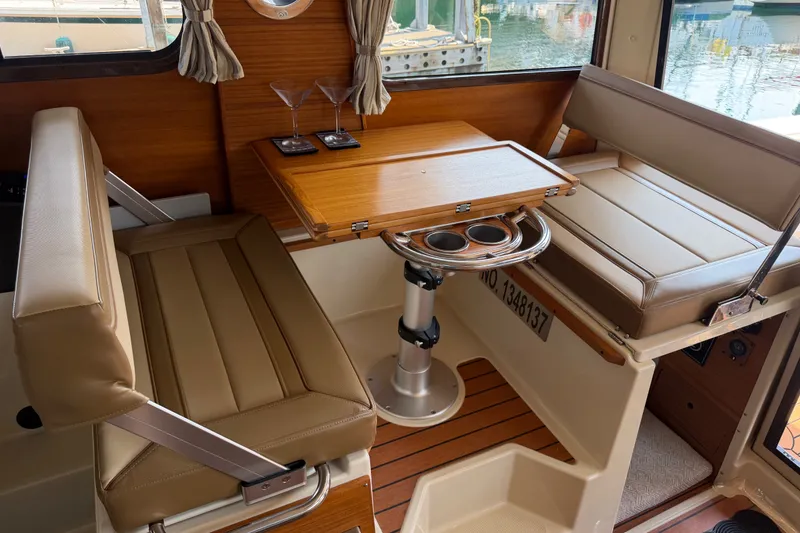 Slide: The Image of Interior of 2024 Ranger Tugs R-27 with seating, table, and cup holders. - 37
