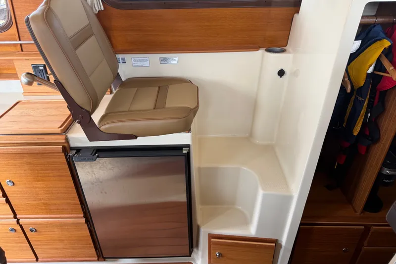 Slide: The Image of 2024 Ranger Tugs R-27 interior with seating and compact refrigerator. - 36