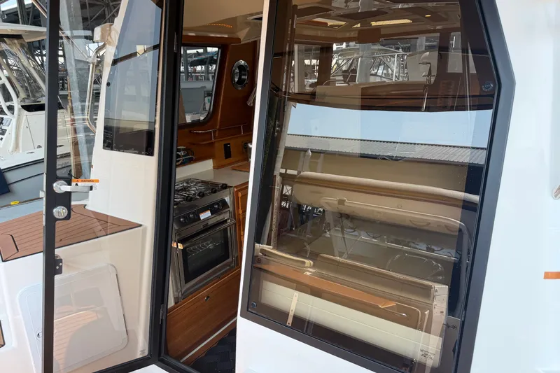 Slide: The Image of 2024 Ranger Tugs R-27 interior view with modern kitchen and seating area. - 17