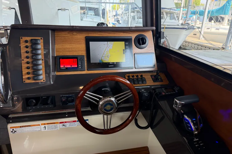 Slide: The Image of 2024 Ranger Tugs R-27 helm with navigation screens and controls. - 26