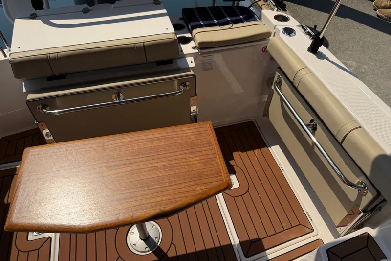 Slide: The Image of 2024 Ranger Tugs R-27 boat interior with wooden table and cushioned seating. - 4