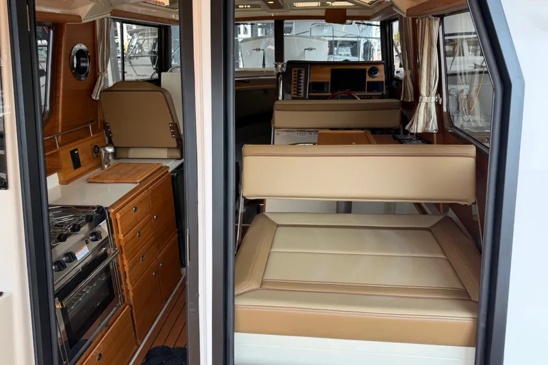 Slide: The Image of Interior of 2024 Ranger Tugs R-27 boat with kitchen and seating area. - 20