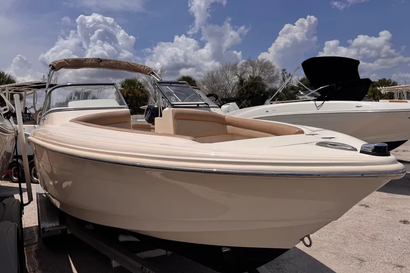 Slide: The Image of 2023 Scout 210 Dorado boat on display under a partly cloudy sky. - 5