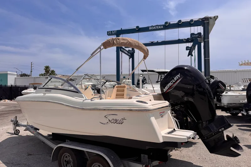 Slide: The Image of 2023 Scout 210 Dorado boat with Mercury engine on trailer at marina. - 2