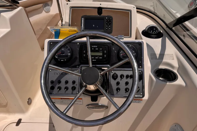 Slide: The Image of Steering console of 2023 Scout 210 Dorado boat with navigation instruments and controls. - 9
