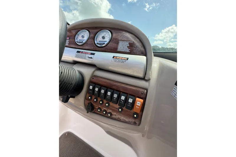 Slide: The Image of Dashboard of 2007 Kayot Z 220 boat with gauges and control switches under a blue sky. - 11