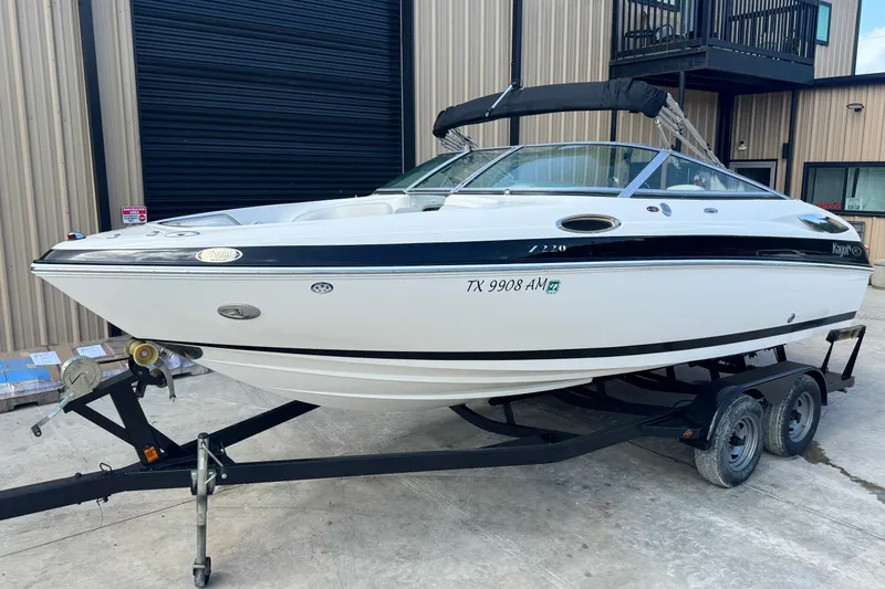 Slide: The Image of 2007 Kayot Z 220 boat on trailer, parked outside a building. - 1