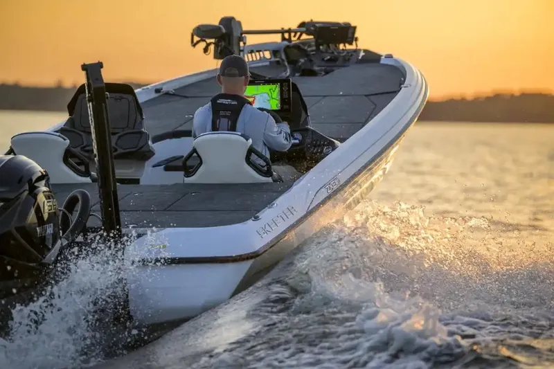 Slide: The Image of Manufacturer Provided Image: 2026 Skeeter ZXE21 boat cruising on water at sunset, featuring advanced navigation system. - 2