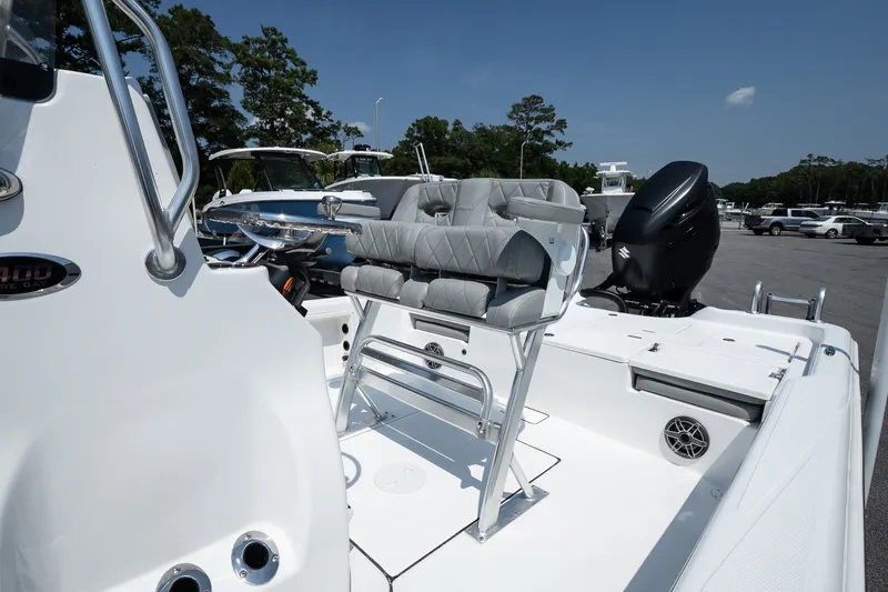 Slide: The Image of 2027 Blazer PureBay 2400 boat interior with seating and motor, parked outdoors. - 12