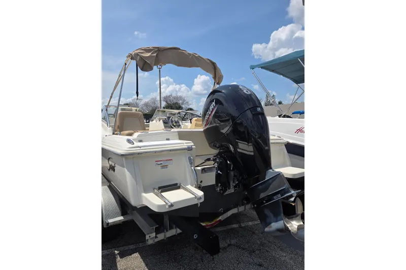 Slide: The Image of 2022 Scout 210 Dorado boat with Mercury outboard motor and canopy, parked on trailer. - 9