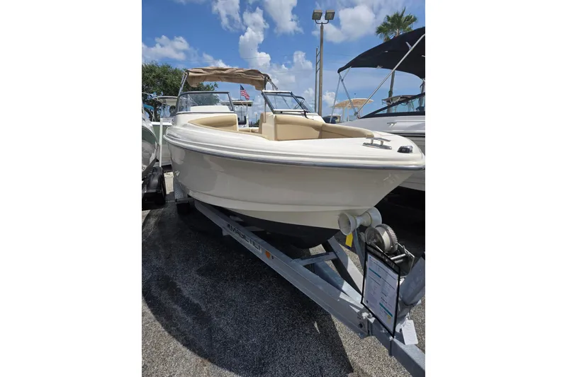 Slide: The Image of 2022 Scout 210 Dorado boat on trailer under clear blue sky. - 7