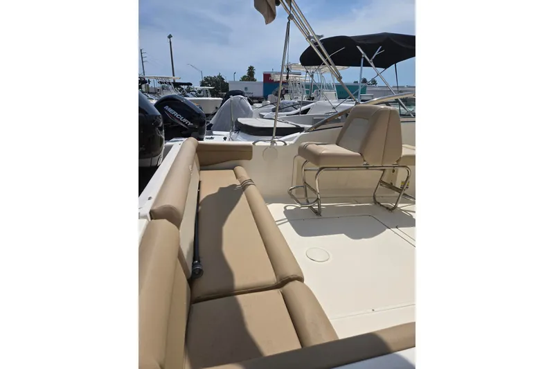 Slide: The Image of 2022 Scout 210 Dorado boat interior with beige seating and Mercury engine. - 4