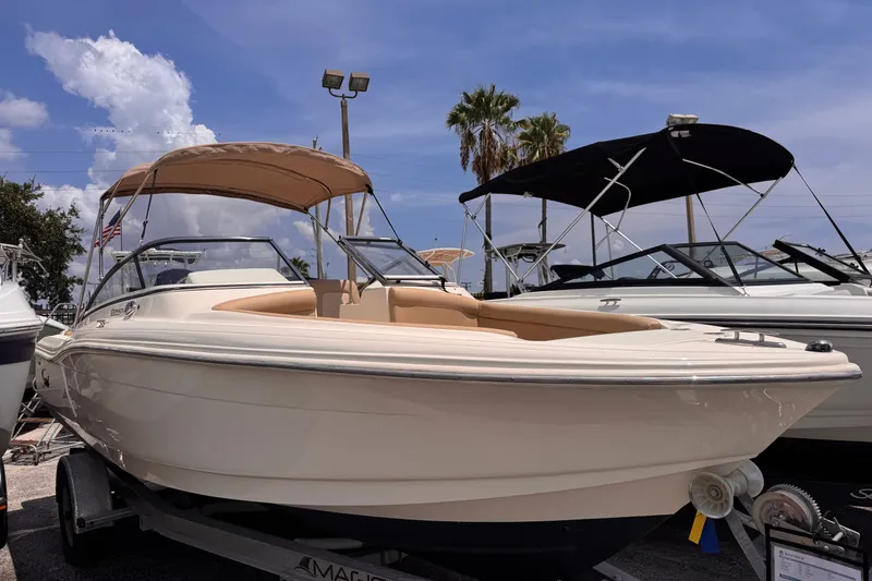 Slide: The Image of 2022 Scout 210 Dorado boat with canopy, displayed outdoors under a clear sky. - 2