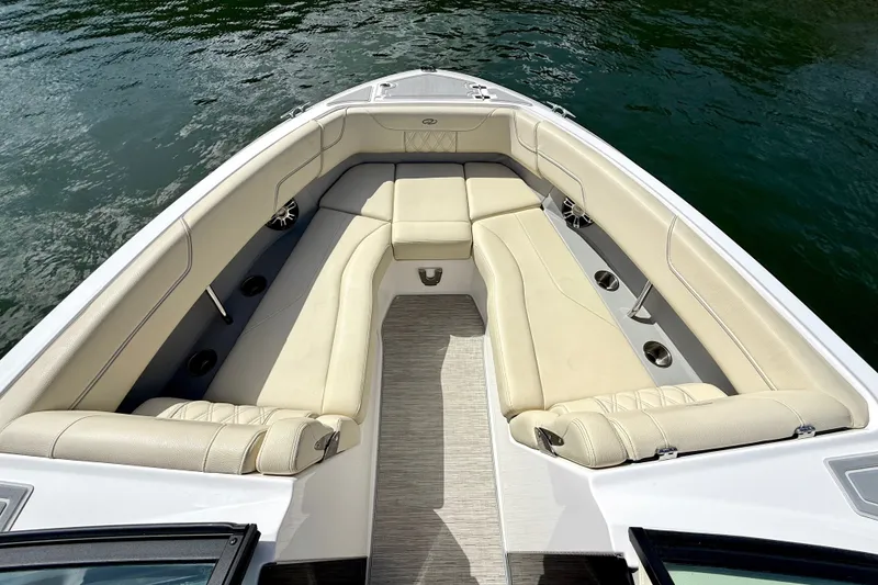 Slide: The Image of Luxurious 2019 Regal LS6 boat interior with beige seating and cup holders on calm water. - 16