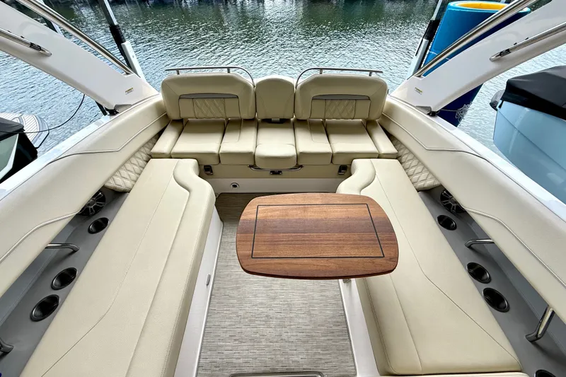 Slide: The Image of Luxurious 2019 Regal LS6 boat interior with beige seating and wooden table. - 25