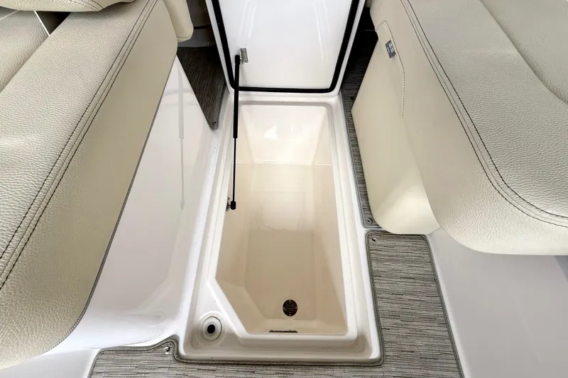 Slide: The Image of 2019 Regal LS6 boat storage compartment with beige seating and textured flooring. - 30