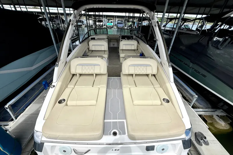 Slide: The Image of 2019 Regal LS6 boat interior with beige seating, docked in a marina. - 18