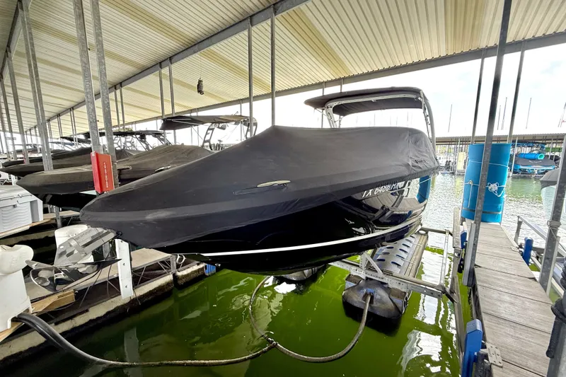 Slide: The Image of Covered 2019 Regal LS6 boat docked in a marina, under a metal roof. - 38