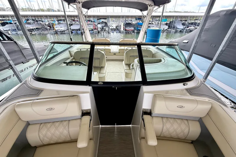 Slide: The Image of 2019 Regal LS6 boat interior with luxurious seating, docked at a marina. - 23