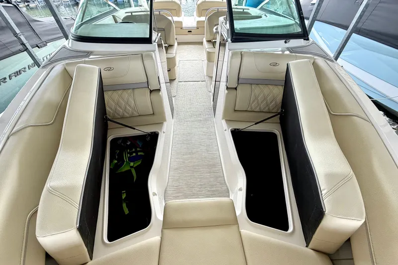 Slide: The Image of Interior view of a 2019 Regal LS6 boat with beige seating and storage compartments. - 33