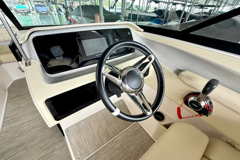 Slide: The Image of Steering wheel and controls of a 2019 Regal LS6 boat, featuring modern dashboard design. - 21