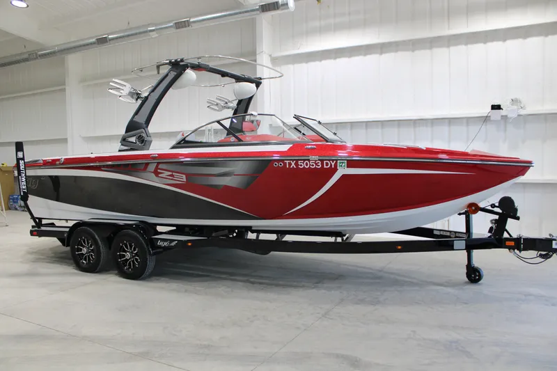 The Image of 2017 Tigé Z3 boat in a showroom, red and black design on a trailer. - 0