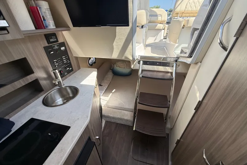 Slide: The Image of Interior of 2023 Regal 26 XO boat featuring kitchenette, seating, and ladder access. - 29
