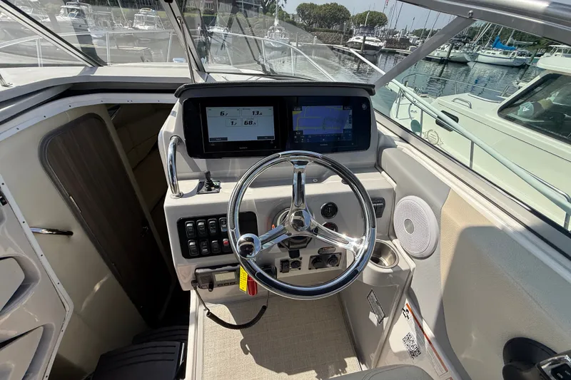 Slide: The Image of 2023 Regal 26 XO boat helm with modern controls and navigation screens at marina. - 19