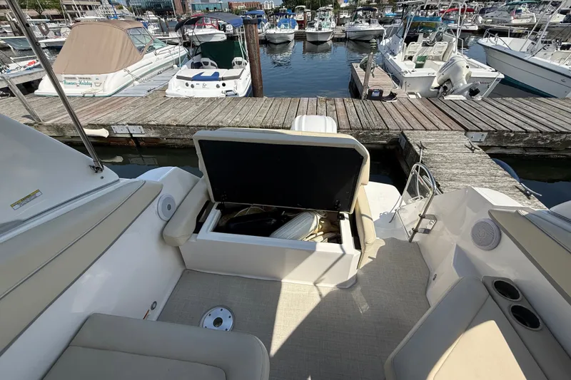 Slide: The Image of 2023 Regal 26 XO boat interior with open storage compartment at marina dock. - 10