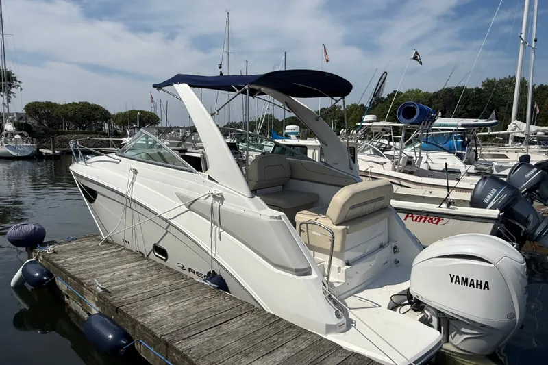 Slide: The Image of 2023 Regal 26 XO boat docked with Yamaha outboard motor, featuring sleek design and canopy. - 1