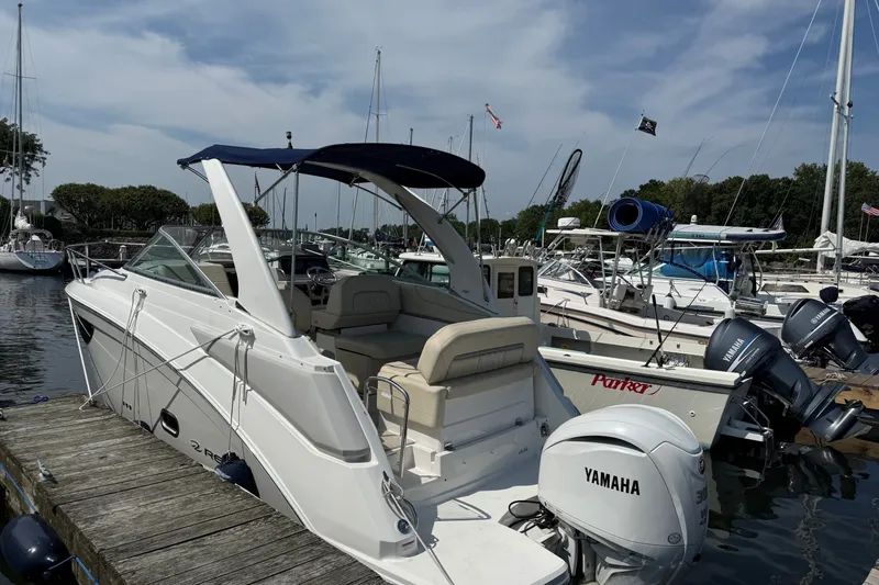 Slide: The Image of 2023 Regal 26 XO boat docked with Yamaha outboard motor, surrounded by other boats. - 2