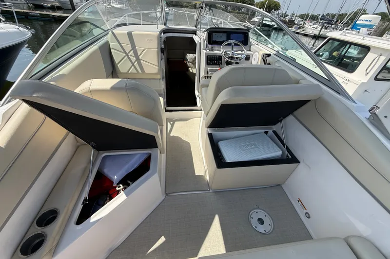 Slide: The Image of Interior of a 2023 Regal 26 XO boat with open storage compartments and helm. - 12
