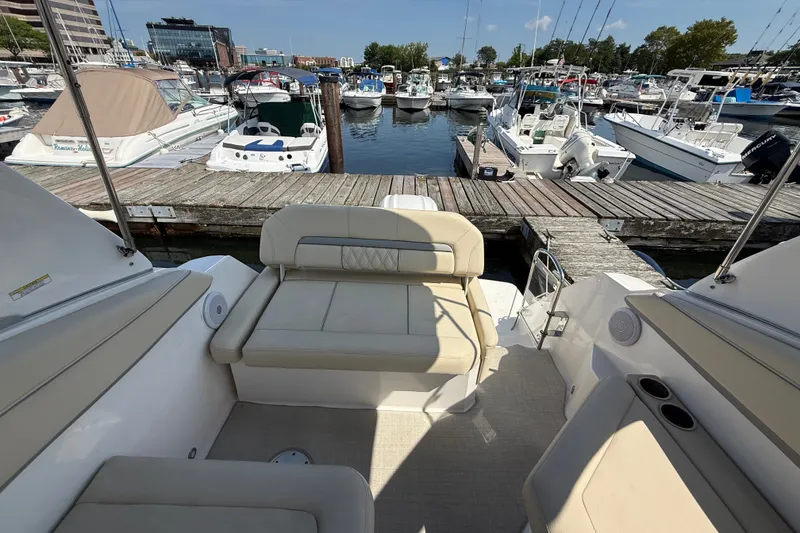 Slide: The Image of 2023 Regal 26 XO boat interior at marina, featuring comfortable seating and docked boats. - 9