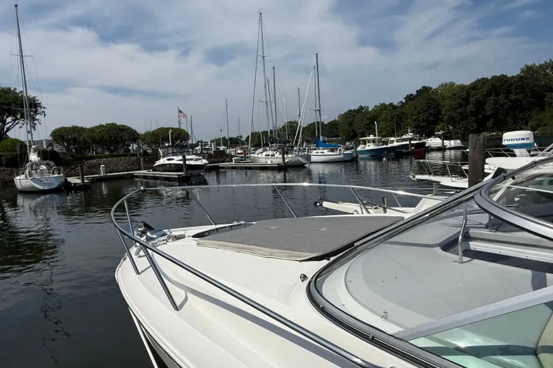 Slide: The Image of 2023 Regal 26 XO boat docked in a serene marina with sailboats. - 24