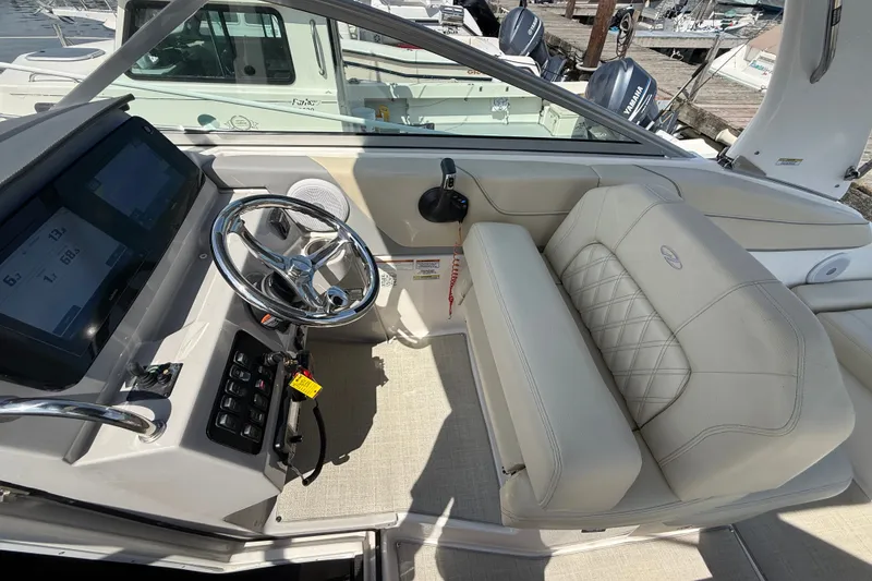 Slide: The Image of 2023 Regal 26 XO boat cockpit with steering wheel and beige seating. - 16
