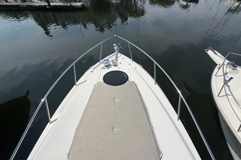 Slide: The Image of 2023 Regal 26 XO boat bow view with sunpad, docked on calm water. - 22