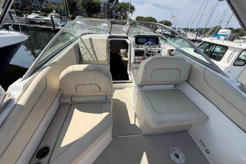 Slide: The Image of 2023 Regal 26 XO boat interior with beige seating and modern dashboard at marina. - 11
